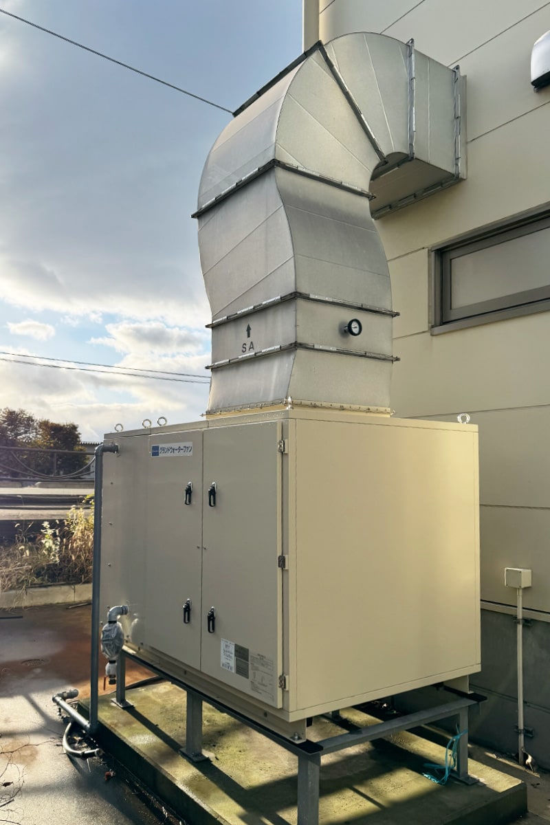 設置写真<br>グランドウォーターファンは工場の横に設置し、ダクトで建屋内に給気する。